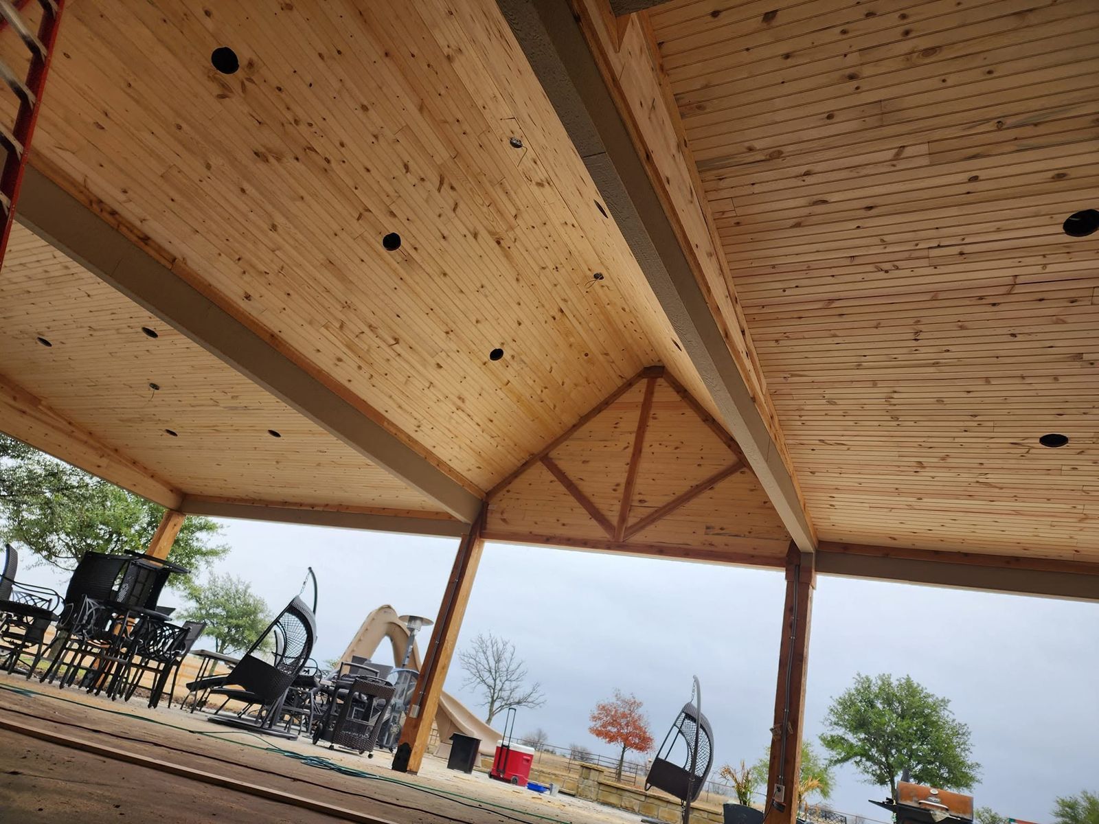 Vaulted stained wood ceiling with exposed truss under a patio cover