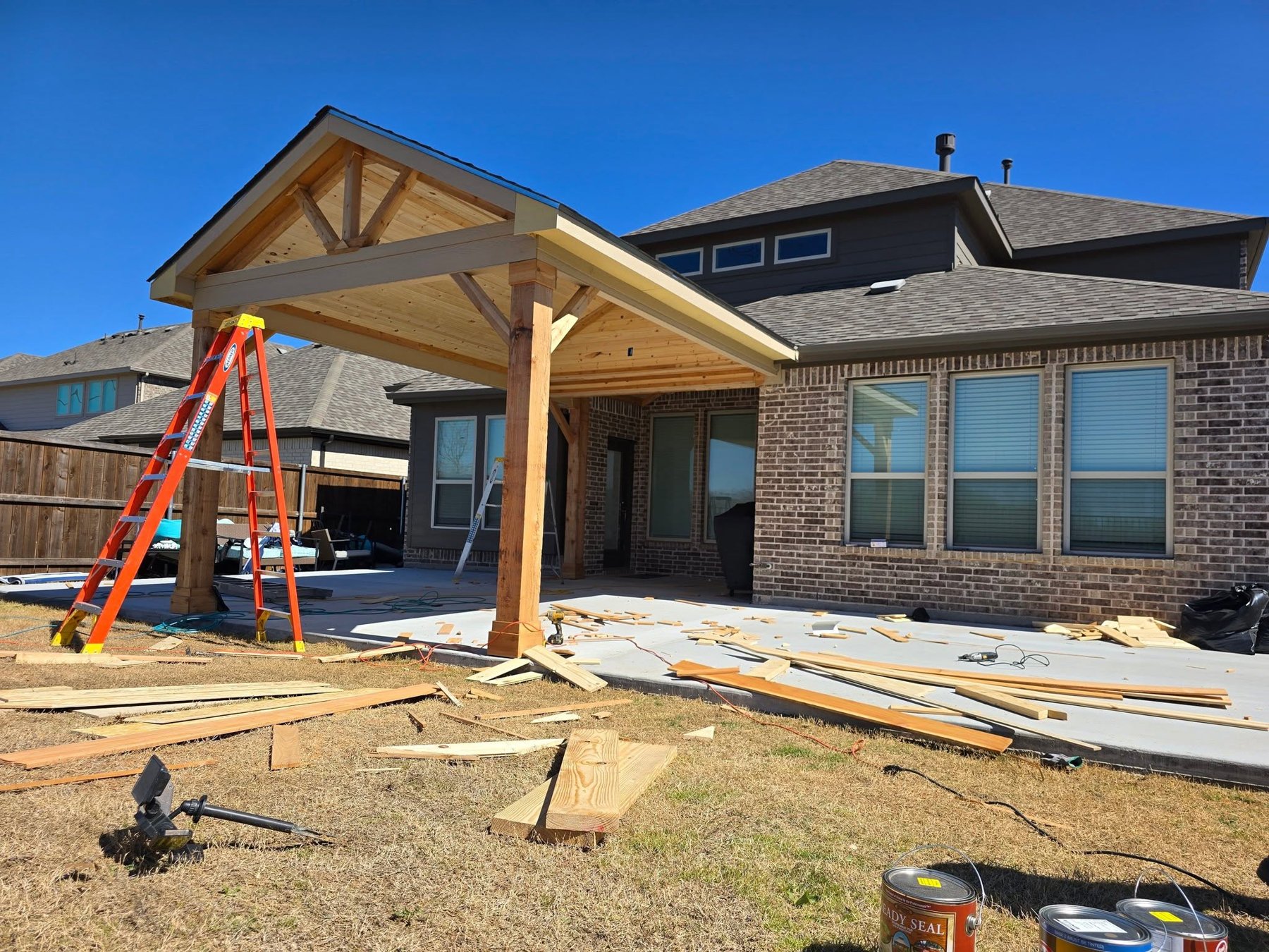 Cedar gable patio cover mid build with the framing up and the trusses exposed