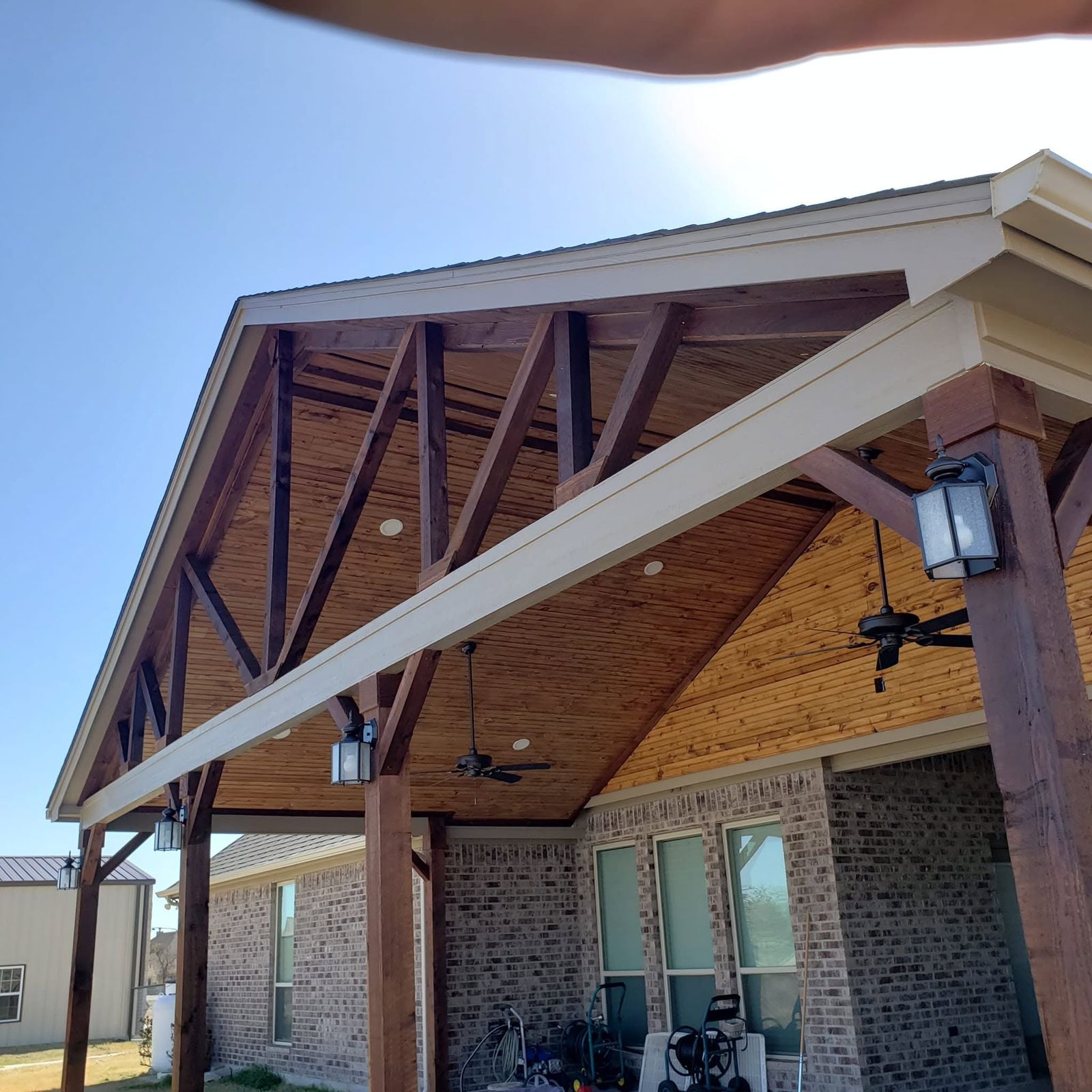 Timber gable patio cover with stone columns and a hanging lantern